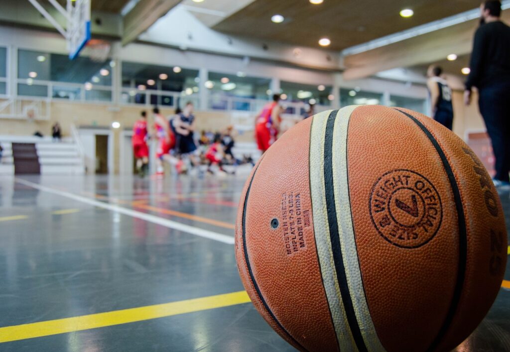 Pelota de baloncesto en el suelo fuera de una esquina de la cancha.