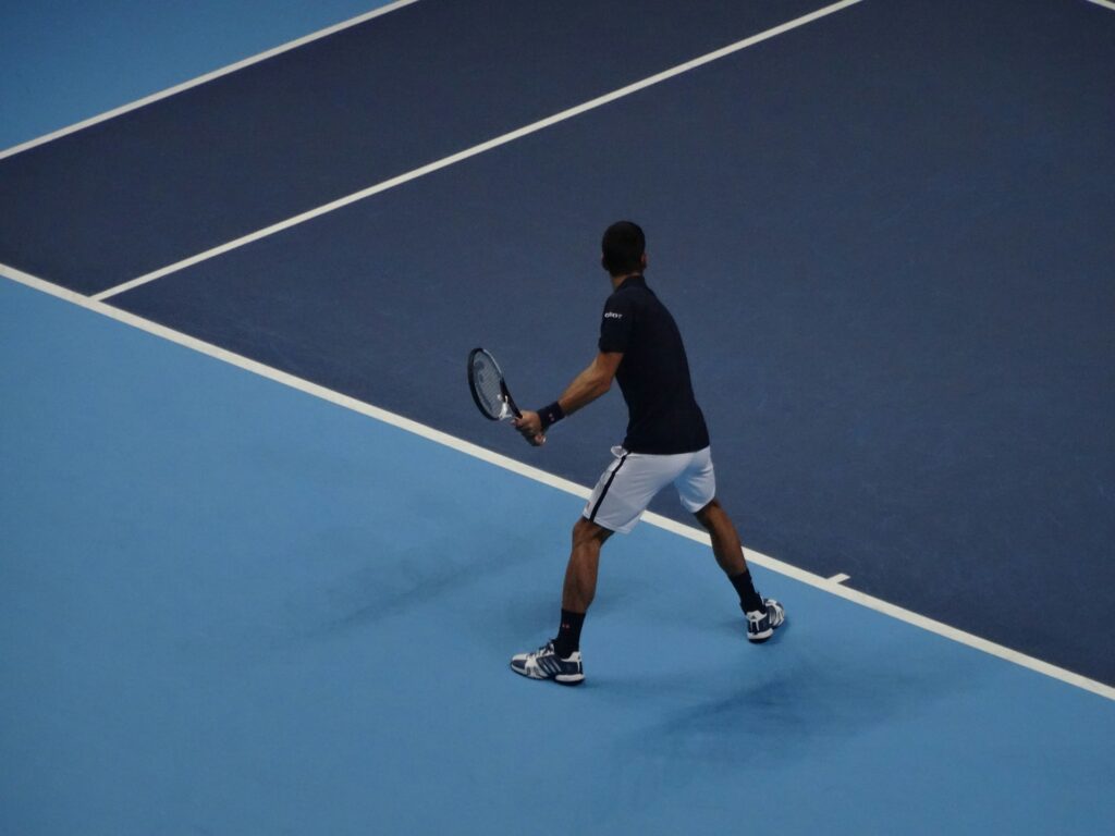 Jugador de tenis en una cancha azul.